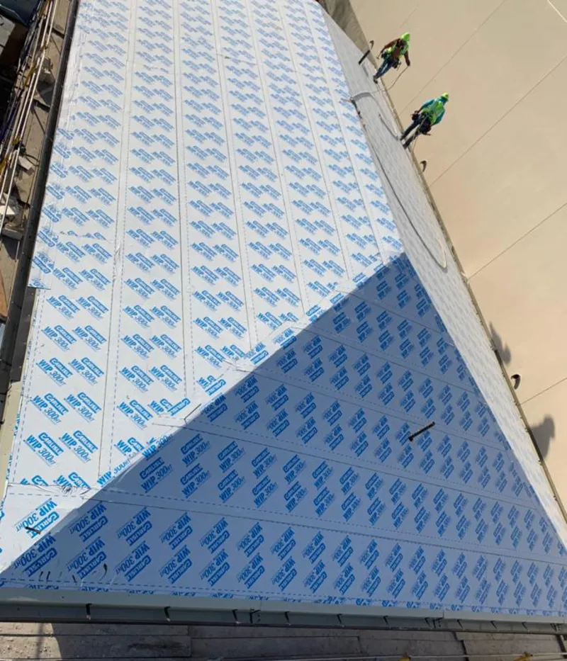 Professional roofers installing underlayment on a metal roof in Medford